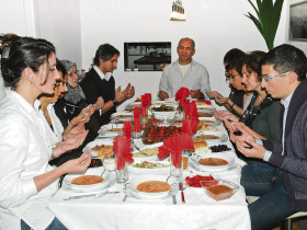 Vor dem Essen wird zunächst gemeinsam gebetet. Gastgeberin Servet Mimaroglu (vorne links) hat für ihre Familie und die Gäste an diesem Abend das Mahl zubereitet