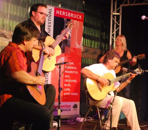 Zum Finale des vielseitigen Konzertabends gaben Michael Langer (links), Don Ross (dahinter), Bob Bonastre (Mitte) und Ross’ Ehefrau (rechts) noch eine gemeinsame Zugabe. Foto: Th. Raum
