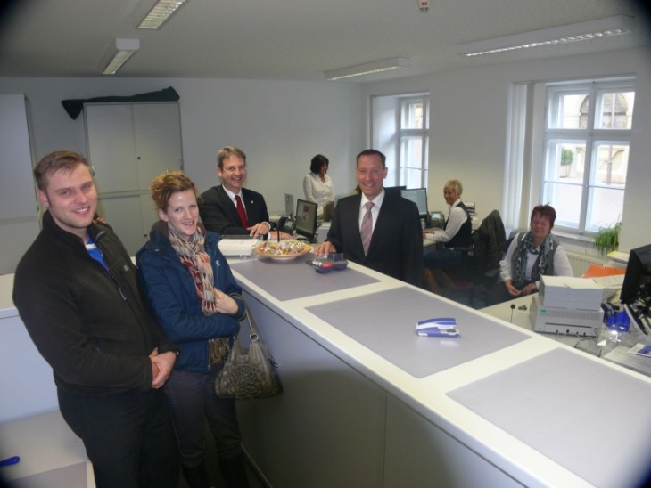 Landrat Armin Kroder (vorn rechts) und seine Mitarbeiterinnen von der Kfz-Zulassung bedienen Brosi Dominic und Barbara Odörfer (links) als eine der ersten Kunden, die ihren neuen BMW gleich in Hersbruck anmelden wollten. Bürgermeister Robert Ilg freut sich über die zusätzlichen Gäste, die jetzt nach Hersbruck kommen. Foto: W. Grzesiek