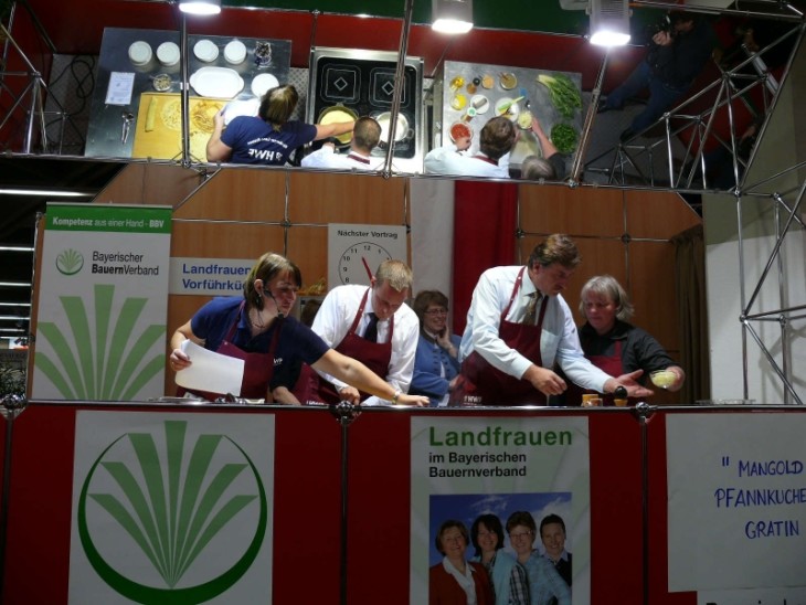 In voller Aktion: Gerdi Maußner, Landrat Armin Kroder, BBV-Kreisobmann Günther Felßner und Gabi Grosch (v. links) beim Zubereiten des „Mangold-Pfannkuchen-Gratins“ in der Schauküche der Landfrauen. Foto: H. Manderscheid