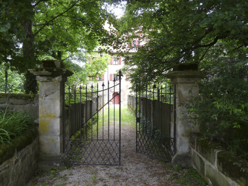 Tor zu einer anderen Welt: Wie ein verwunschenes Schloss verbirgt sich das Anwesen hinter einem dichten grünen Blätterdach.