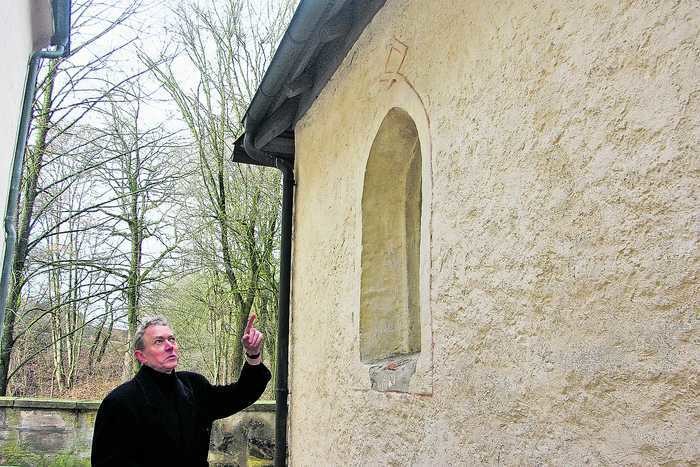 Drei Runen finden sich über den Fensterbögen an der Außenwand, erläutert Pfarrer Ulrich Kleinhempel: die Zeichen für die Göttin Gefjon, für den Gott Ing und für Wodan
