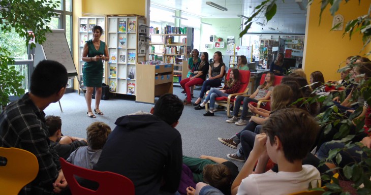 Im Halbkreis sitzen die Schüler in der Bibliothek um die Märchenerzählerin Bouin und hören ihr gebannt zu. Foto: Klüpfel