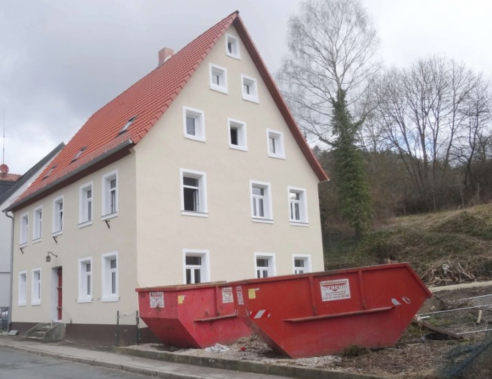 Zunächst wird das Wohnhaus saniert. Die Container fassen verkohlte Überreste. Foto: S. Fuchs