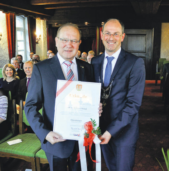 Linkes Bild: Christoph Grassl und Peter Schwarzer von der Laufer Musikschule umrahmen den Festakt im Saal des Alten Rathauses. In der ersten Reihe sitzen von links Rüdiger Pompls Sohn Raphael und seine Ehefrau Petra. Rechtes Bild: Altbürgermeister und neuer Laufer Ehrenbürger Rüdiger Pompl nach der Überreichung der Urkunde durch seinen Amtsnachfolger Benedikt BispingFotos: Fischer