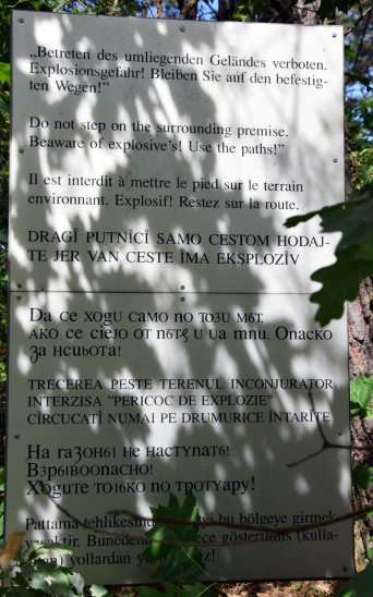 Das Warnschild im Dickicht, das in acht Sprachen auf die Gefahren hinweist. Es steht an der Straße, die an der Grenze des Bereichs Moser Brücke direkt zum GNF führt
