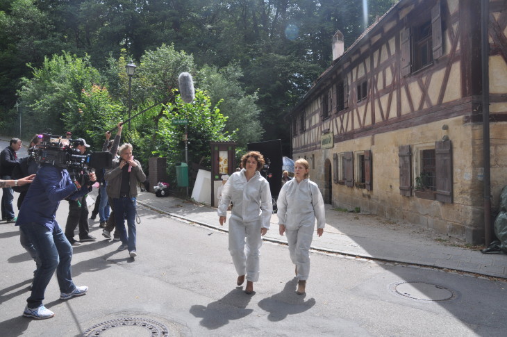 Die Kameras laufen: Die Kommissare untersuchen einen Lada, der dem Mann der ermordeten Wirtin gehört (linkes Bild). Regisseur Andreas Senn (Mitte, grüne Jacke) beobachtet, wie Eli Wasserscheid und Dagmar Manzel als Kommissarinnen Wanda Goldwasser und Paula Ringelhahn ermitteln (rechtes Bild)