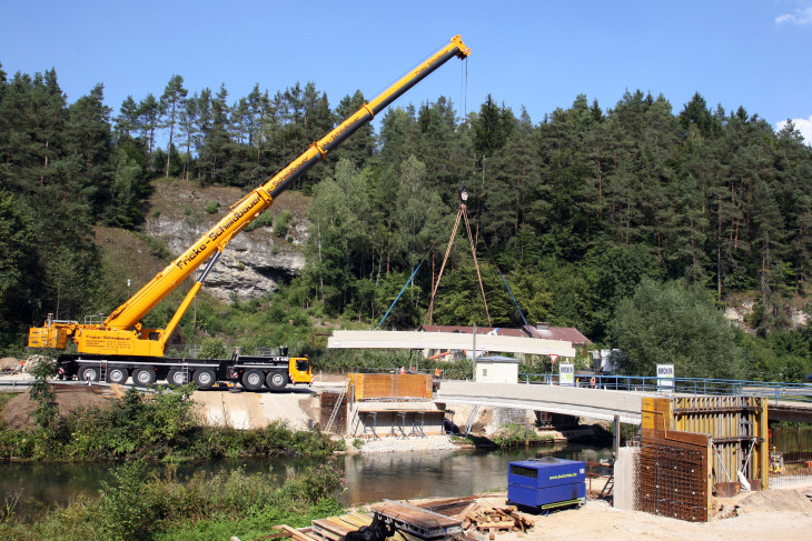 Mit einem Autokran wurden die bis zu 28 Tonnen schweren Stahlbetonfertigteile der neuen Pegnitzbrücke bei Lungsdorf auf ihren vorgesehenen Platz gehievt. Foto: A. Tauber