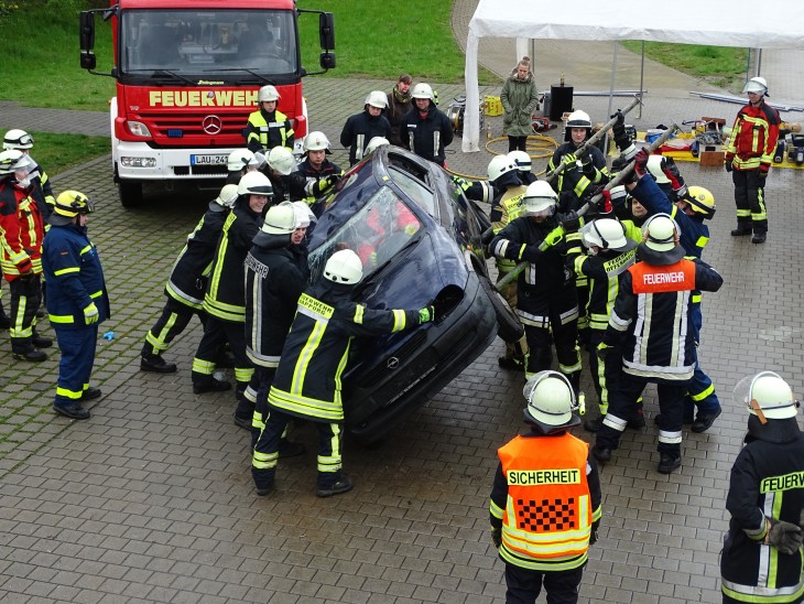 Nicht immer wird schweres Gerät benötigt: Ein Unfallwagen wird mit Muskelkraft wieder auf die vier Räder gestellt.