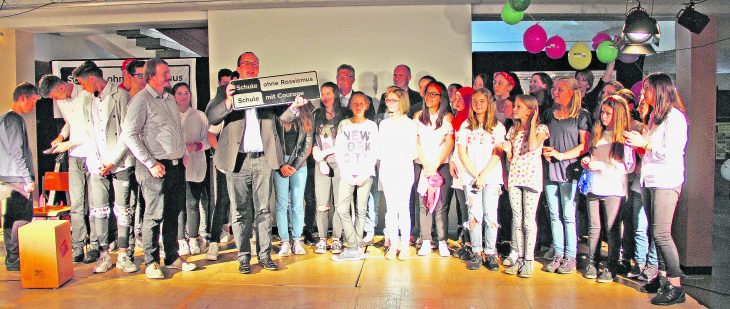 Schwarz auf weiß, weiß auf schwarz: Schule ohne Rassismus – Schule mit Courage. Stolz nehmen die Schüler der Realschule Feucht das Schild mit ihrem neuen Titel entgegen.