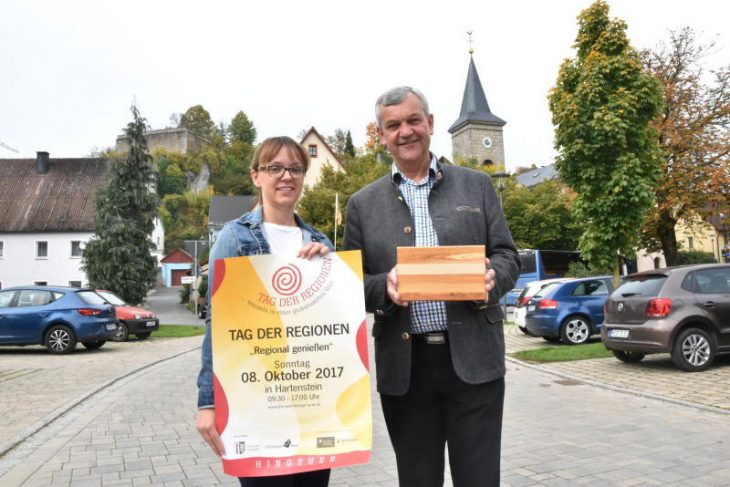 Christina Reinhardt vom Landratsamt (links) und Bürgermeister Werner Wolter zeigen das Plakat und das neue „Genuss-Brettchen“.