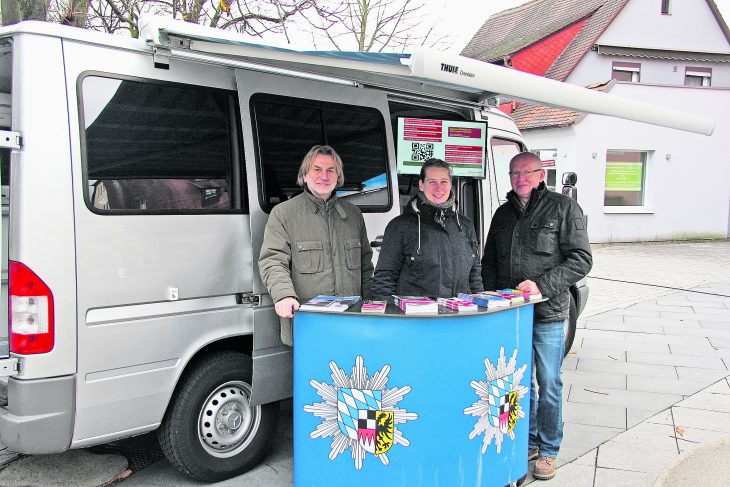 Walter Eibl, Peggy Emmrich und Franz Burnikel beraten Passanten an ihrem Stand vor der Sparkasse Feucht (von links)