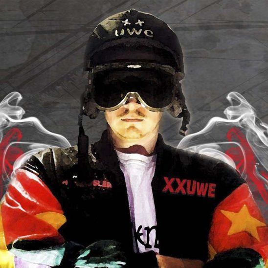 XXUwe mit seinem Skihelm und der bunten Lederjacke, im Hintergrund Rauch in den Farben des Clubs.