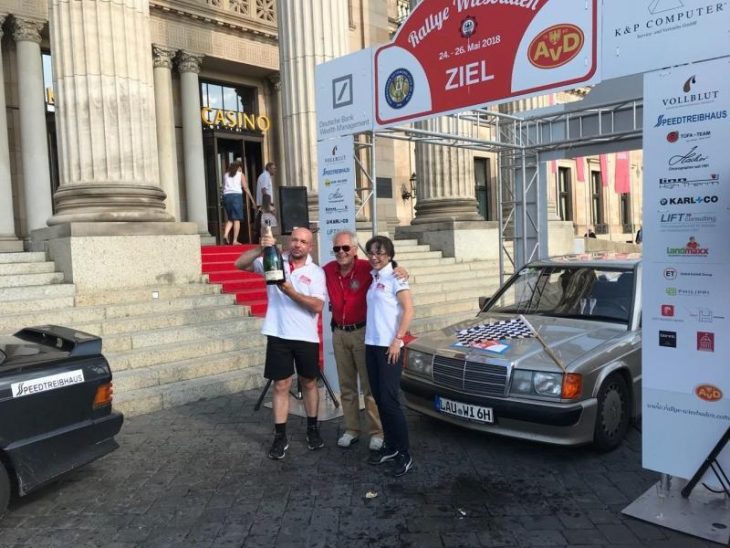 Das Bild entstand am Ziel vor dem Kurhaus in Wiesbaden: Der Präsident des Wiesbadener Automobilclubs im AvD, Norbert Seezer, steht zwischen Roland und Vera Wittmann und wartet auf die Sektdusche.