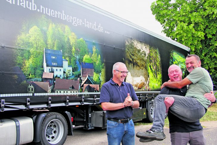 „Bei uns werden die Fahrer getragen“, scherzt Spediteur Klaus Neukam (oben, links) beim Fototermin mit seinen Mitarbeitern. Seine Lastwagen zeigen das Nürnberger Land als Kletter-, Kanu- und Wanderziel.