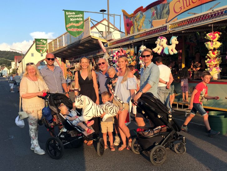 Die Familie Abt mit ihrem Hauptgwinn an einer Bude auf dem Rummelplatz in der Dorfmitte: einem weißen Stofftiger.