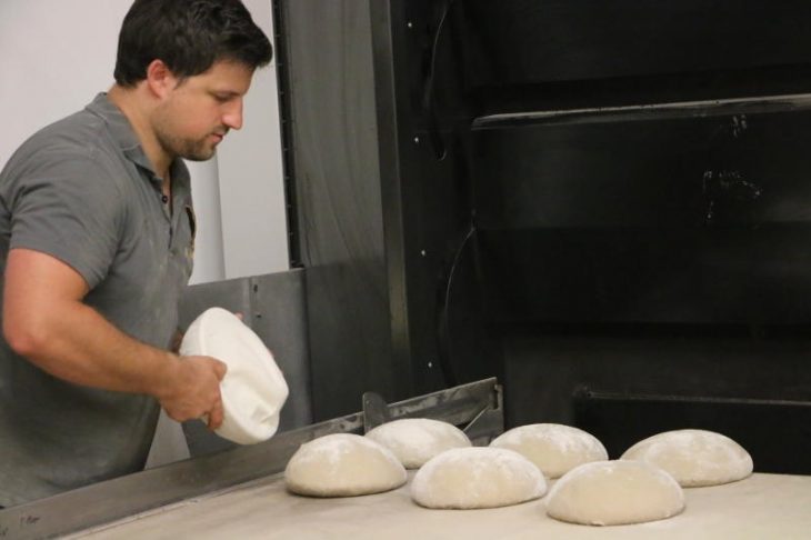 Anja Bär befreit die Brot-Teiglinge nach dem Ruhen von den Tüchern, damit Daniel Bär sie fürs Backen im modernen Holzofen aufschlichten kann.