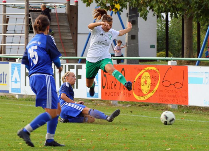 Beobachtet von der Schwabthaler Teamkameradin Janine Hofmann (Nr. 15) geht Jessica Keil kompromisslos gegen Gegner und Geläuf vor, die Ezelsdorferin Melanie Schneider (Grün/Weiß) rettet sich gerade noch mit einem beherzten Sprung.