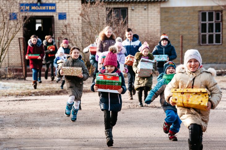 Eine Schule in der Ukraine: Jubelnd rennen die Kinder mit ihren Päckchen nach Hause. Für manche ist es das erste Geschenk ihres Lebens.
