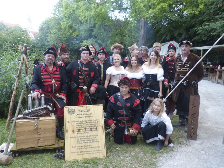 Die Kosaken sind eine von über 20 Gruppen, die mit ihren historischen Kostümen die Wallenstein-Festspiele lebendig und für ein großes Publikum attraktiv machen. Im vergangenen Jahr haben sie - wie alle anderen teilnehmenden Gruppen auch - auf hölzernen Infotafeln Auskunft darüber gegeben, dass sie beispielsweise zu den Aufklärungstruppen im Heer Wallensteins gehörten. Gehalten sind die Texte in Erasmus-Luther-Frakturschrift. Dafür gab es den Stiftungspreis der Stiftung Deutsche Schrift.