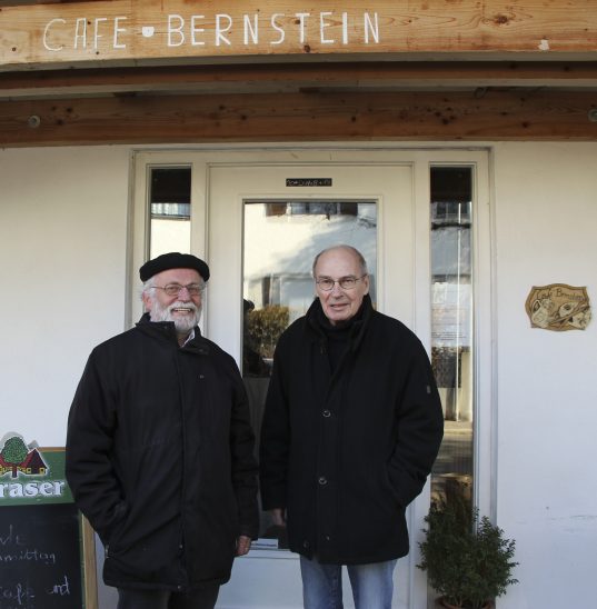 Ernst Klier (links) und Hans-Joachim Strauß vor dem Café Bernstein, das derzeit den Themenkunstverein beherbergt. Nun aber ist gemeindliche Unterstützung angesagt, finden die beiden, und hoffen auf Hilfe aus dem Rathaus. 
Foto: Gisa Spandler