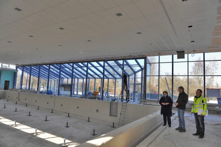 Bürgermeisterin Ruth Thurner lässt sich von Architekt Peter Lindig und Bauleiter Swen Kellner (v. l.) auf den neuesten Stand der Sanierungsarbeiten bringen. In der Schwimmhalle ist bereits die montierte neue Deckenverkleidung zu sehen.