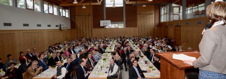 Kreisbäuerin Marion Fischer begrüßt die Gäste in der voll besetzten Ottensooser Mehrzweckhalle zum Landfrauentag. Vorne links am dritten Tisch von links: Festredner Albert Füracker.
