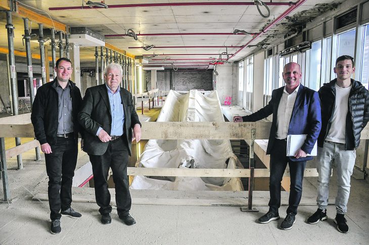 Die künftigen Marktbetreiber Christoph Schmitt (links) und Wolfgang Louzil (2. v. rechts mit Sohn Leon) sowie Reiner Anselstetter als Vertreter des Eigentümers vor den neuen, noch abgedeckten Rollsteigen.
