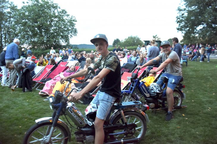 Simon Winkler (v.l.) und Thomas Rühl sind mit ihren 25 km/h schnellen Maschinen zum Sommerkino gefahren. Jeder der am Freitag mit dem Mofa kam, durfte kostenlos Popcorn naschen. Anlass war der Film des Abends „25 km/h“.