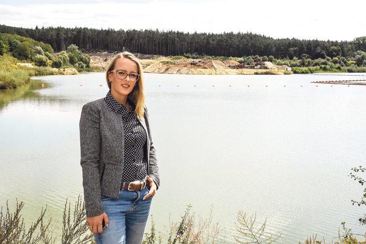 Geschäftsführerin Lisa Hammerand vor einem der beiden riesigen künstlichen Seen im Firmenareal bei Großbellhofen. Das Unternehmen möchte die Abbausohle im Nassabbau  vertiefen und in einer trockenen Mulde Erdaushub der Qualität Z2 verfüllen. Was das Bergamt erlaubt, will der Markt nun verhindern.