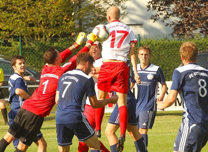 Keeper Fabian Liedel vom FC Ottensoos faustet einen Eckball weg, der hochgestiegene Erlanger Angreifer Marius Meyer kommt nicht ans runde Leder.