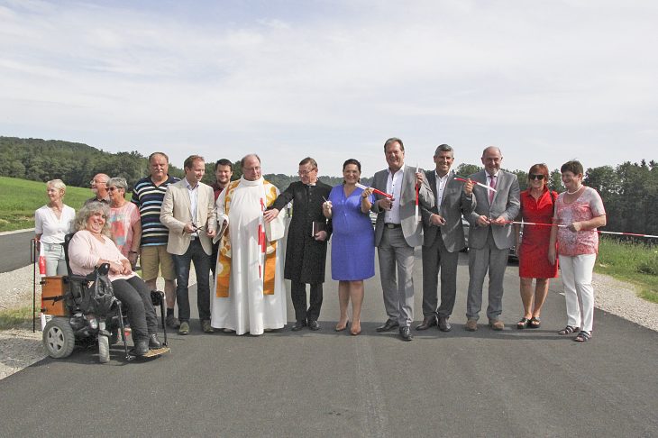 Bei strahlendem Einweihungswetter durchschnitten das Band die Bürgermeister Kratzer und Meyer (4.und 5. v.l), Landrat Gailler (3.v.r.), stellvertretende Landrätin Trinkl (6.v.r.) sowie Bauausführende, Geistliche und Gemeinderatsmitglieder.