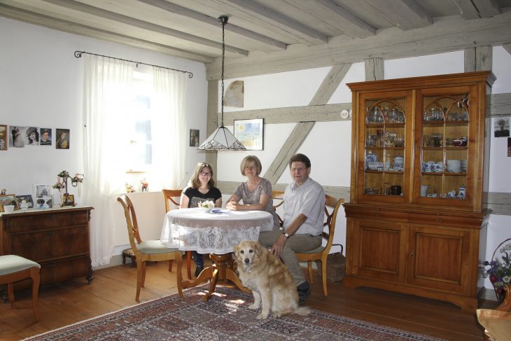 Oben die jahrhundertealte Balken-Bohlendecke, seitlich das Fachwerkgebälk, und am Tisch ein Teil der Familie Wenzel mit Klaus-Dieter, Kirsten und der elfjährigen Jule.
