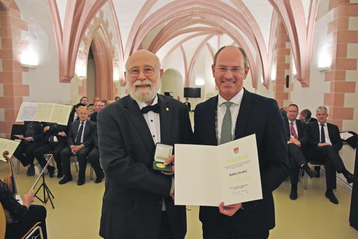 Baldur Strobel (links) ist seit Freitagabend Träger der Goldenen Bürgermedaille der Stadt Lauf, die von Bürgermeister Benedikt Bisping in einer außerordentlichen Stadtratssitzung überreicht wurde.