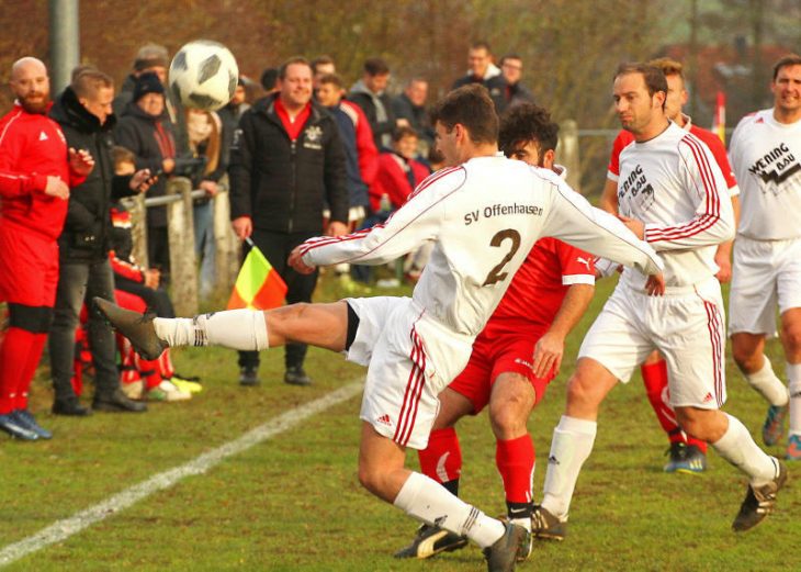 Manuel Schmidt vom SV Offenhausen (in weiß, Nummer 2) schießt an der Außenlinie einen hohen Ball nach vorne Richtung Tor des TSV Röthenbach.