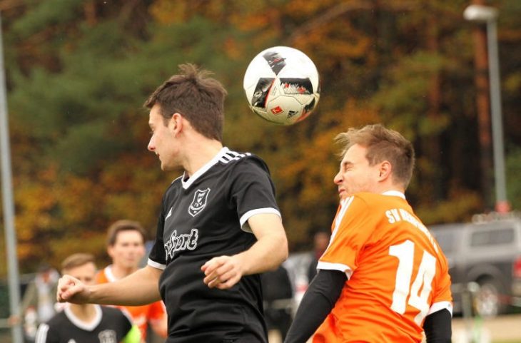 Der Henfenfelder Michael Putz (rechts) und Aaron Jones vom TSV Rückersdorf (dunkler Dress) liefern sich an der Mittellinie ein Kopfballduell um den Ball.