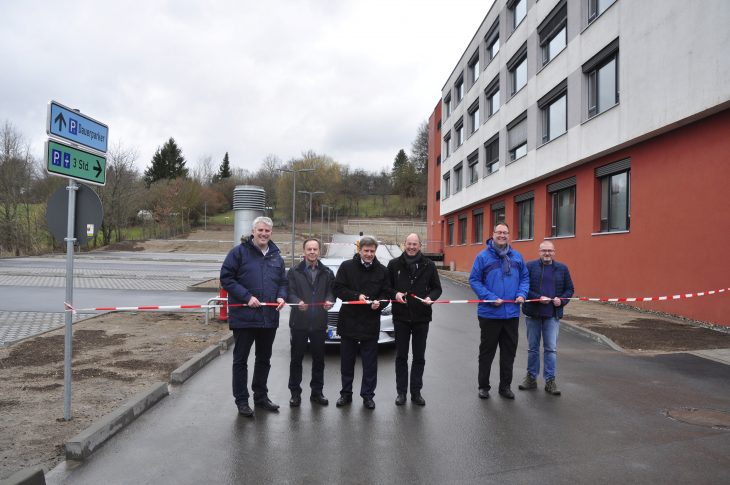 Bürgermeister-Stellvertreter Thomas Lang, Hermann Müller, Leiter Bau und Technik am Krankenhaus, Geschäftsführer Thomas Grüneberg, Bürgermeister Benedikt Bisping, Bürgermeister-Stellvertreter Norbert Maschler und Betriebsratsvorsitzender Peter Herbach (von links) schneiden gemeinsam das Band vor den neuen Parkplätzen durch.