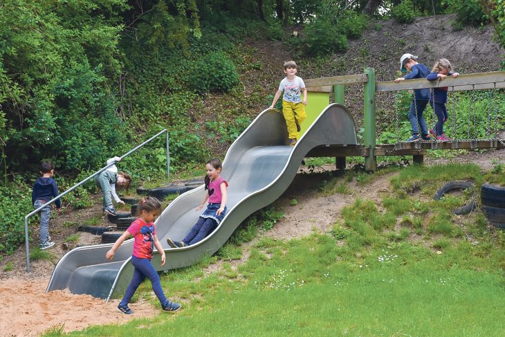 Endlich wieder mit Freunden spielen: 26 von 66 Kindern sind inzwischen wieder in den städtischen Kindergarten „Am Hardt“ in Lauf zurückgekehrt und vergnügen sich unter anderem auf der Rutsche im Garten.