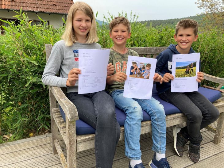 Stolz halten Sophie, Max und Felix Rogoz (von links) ihre Exemplare der „SMF-Zeitung“ in die Kamera.