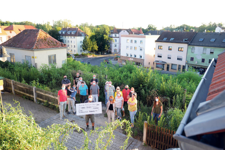 Ihre Grundstücke liegen oberhalb des Kinobergs (im Hintergrund): Die Anwohner – hier mit Protestplakat – kritisieren das Vorgehen der Berger-Gruppe.