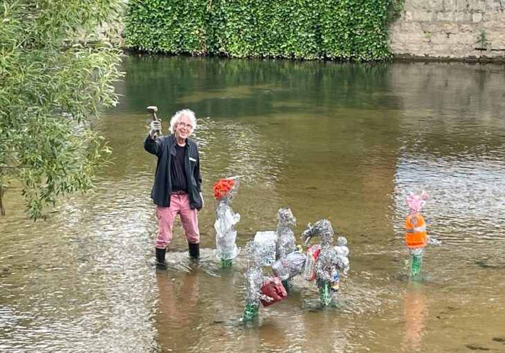 Dieter Serfas steht in der Pegnitz, um seine Figurengruppe, die er mit Gerlinde Berger gestaltet hat, zu befestigen.