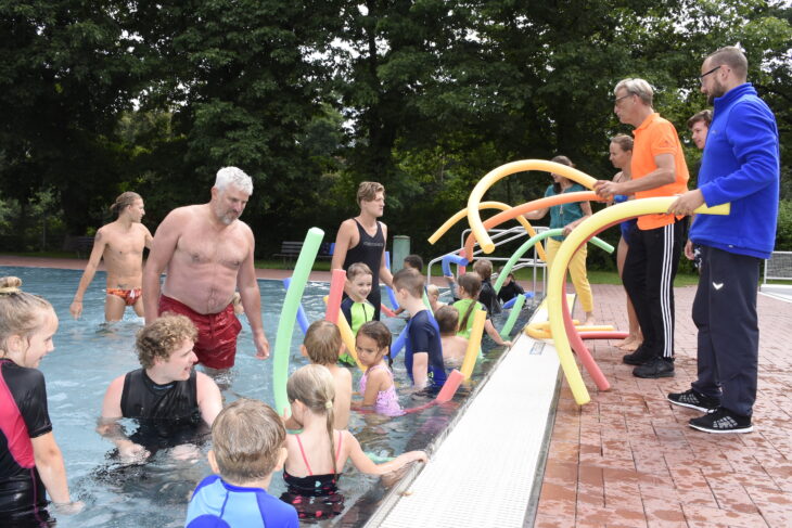 Während des Schwimmkurses im Laufer Freibad verwenden die Schüler unter anderem die Schwimmnudel als Hilfsmittel. Bürgermeister Thomas Lang (4. v. l.), Schwimmschulleiter Alexander Gallitz (3. v. r.) und Grünen-Stadträtin Erika Vogel (5. v. r.) halfen am Dienstag den Lehrern der Schwimmschule Flipper aus Burgthann.