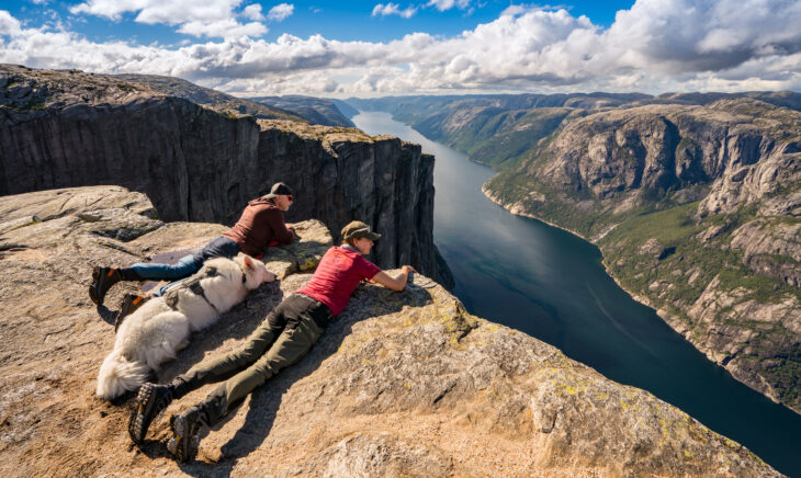 Tanja und Denis Katzer blicken mit ihrem Hund Ajaci, der sie stets begleitet, auf den 1000 Meter unter ihnen gelegenen Lysefjord.