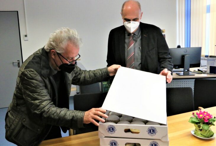 Dieter Bärmann vom Lions Club (links) öffnet für den neuen PPG-Chef Rolf Rosignuolo die bestellte Krapfenkiste. Für den Schulleiter, der erst seit Montag im Amt ist, war die Aktion eine kleine Überraschung.