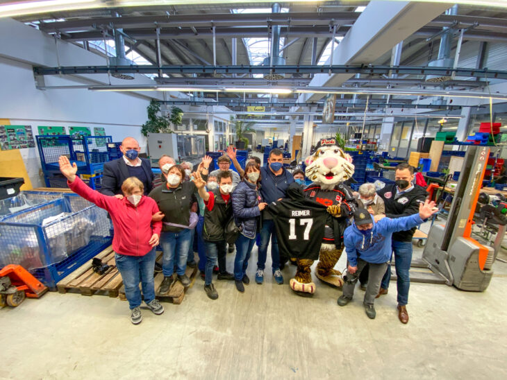 In Begleitung von Nürnberg Ice Tigers Maskottchen 'Pucki' nahmen Familie Buchhauser von Buchhauser Gebäudeservice Nürnberg (Bildmitte) und Vorstandsmitglied Andreas Kurzer (rechts außen) von PIC Capital Partners ihre Zip-Hoodies in Empfang.