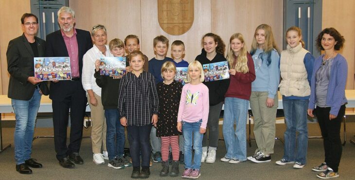 Präsentation des neuen Lions Adventskalenders: Lions-Präsident Stefan Buchholz, Bürgermeister Thomas Lang, Heike Krames (von links) und Kinder der Kreativklasse mit ihrer Kunstlehrerin Birke Wolf.