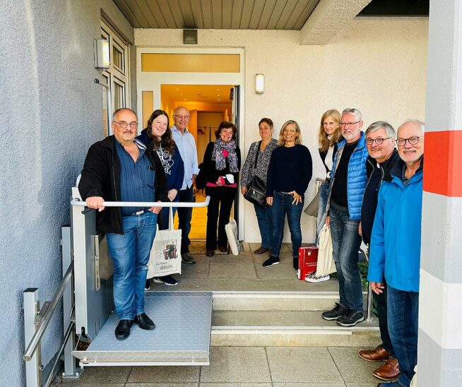 Das Wohnberatungsteam mit Gerhard Kunz vom Landratsamt Roth (3. von links) und Kerstin Stocker, Leiterin des WinWin Freiwilligenzentrums (6. von links), beim Erproben des Treppenlifts der TABEA Musterwohnung.
