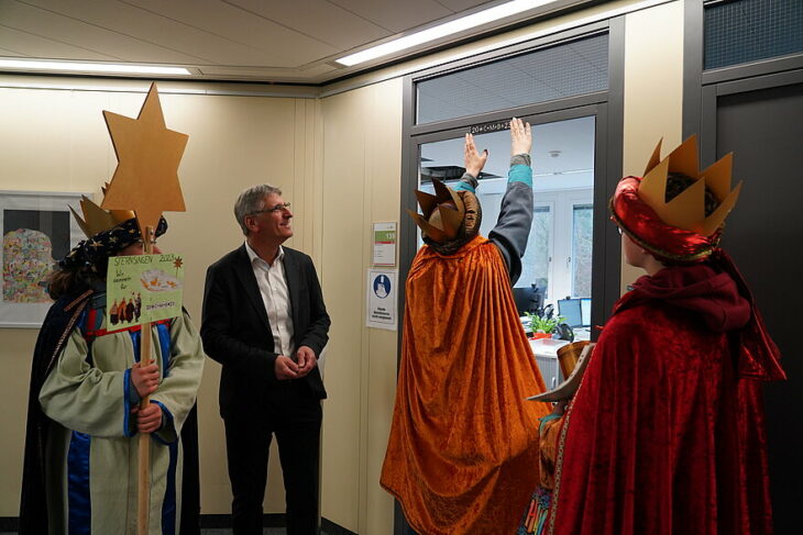 Der stellvertretende Landrat Helmut Brückner freut sich über den Besuch der Sternsinger und die Segenszeichen an der Bürotür.