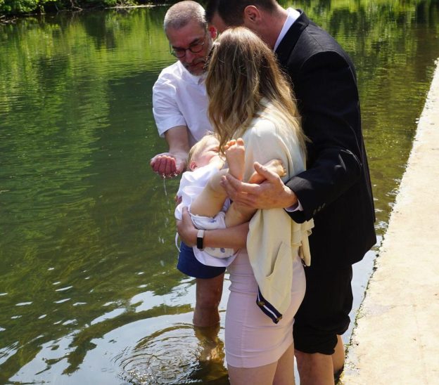 Vier Kinder wurden am Ufer des Flusses getauft.
