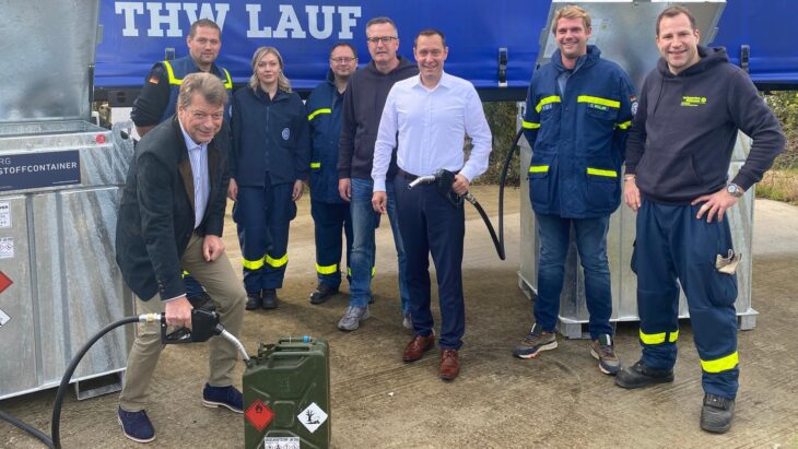 Sparkassen-Vorstand Matthias Benk (links) bei einem symbolischen Funktionstest. Landrat Armin Kroder (Bildmitte) ist sichtlich erfreut, der Bevölkerung diesen Sicherheitsbaustein zur Verfügung stellen zu können. Links daneben der Vorsitzende des Fördervereins, Gerhard Stiegler, umrahmt von einigen der engagierten Helfer des THW Ortsverbands Lauf – Nürnberger Land.
